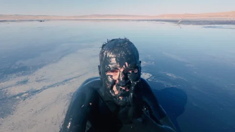 A man smears himself with therapeutic mud in a mud lake. Therapeutic mud. Stock Footage 316838844