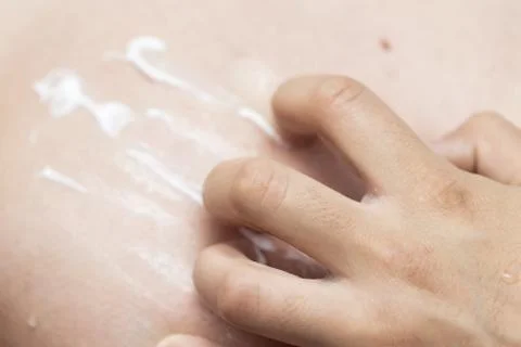 Man smears sunscreen Stock Photos