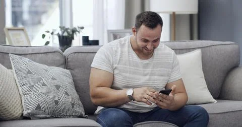 Man, smile and scroll on sofa with phone, text message notification and dow.. Stock Photos