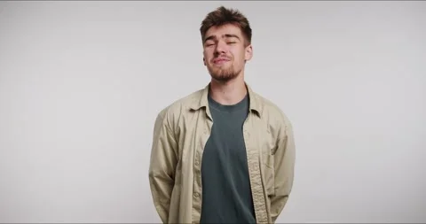 Man smiles and laughs in a simple indoor setting while wearing casual clothin Stock-Footage 331796927