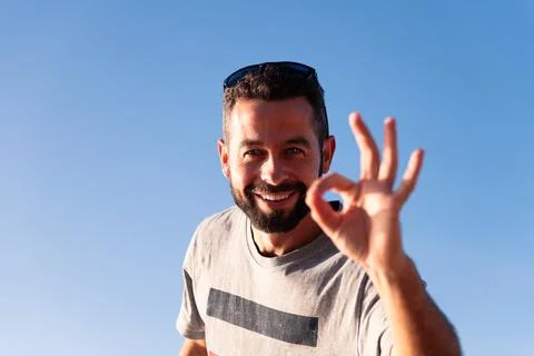 Man smiles looking at camera making the OK symbol Foto stock