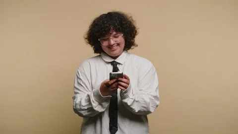 Man smiles while looking at phone and reacts happily in studio Stock-Footage 331990578