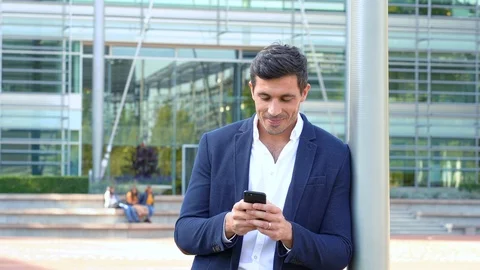 Man smiling and laughing while texting in business park 4K Stock Footage 96065408