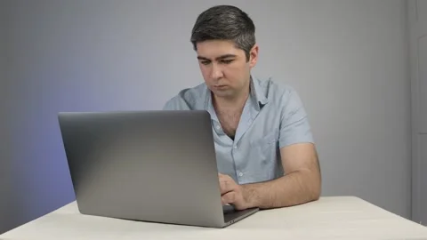 Man smiling and typing on laptop chatting with someone Stock Footage 169443000