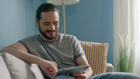 Man Is Smiling and Using Tablet Computer 스톡 동영상 129889755