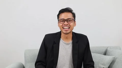 Man smiling and waving at camera during a virtual video conference, friendly Stock Footage 336509991