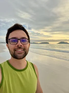 Man smiling on the beach at sunset Stock Photos