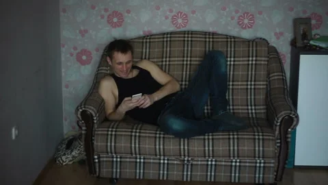 Man smiling browsing the phone Stockbeeldmateriaal 87405106