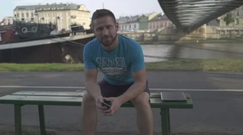 Man is smiling to camera and takes photo by smatphone. Vídeo Stock 65205221