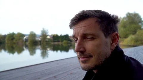 Man smiling to the camera at a lake 库存影片 97137753