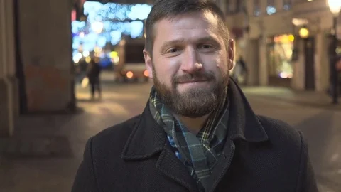 Man smiling at camera at night, city Christmas time, close Steadicam shot Vídeos de archivo 72781737