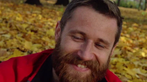 Man smiling to the camera in the park, steadycam shot, slow motion shot at 240fp Stock-Footage 57773217