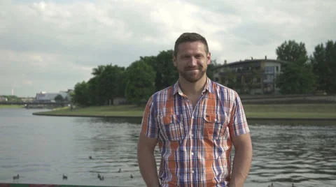 Man smiling to camera by the river.  Vídeo Stock 52697081