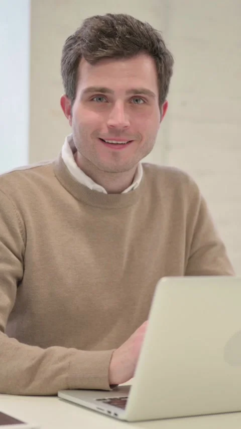 Man Smiling at Camera while using Laptop in Office, Vertical Video Stock Footage 337351178