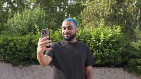 Man smiling chewing during video call with a friend using smartphone Stock Footage 285660077