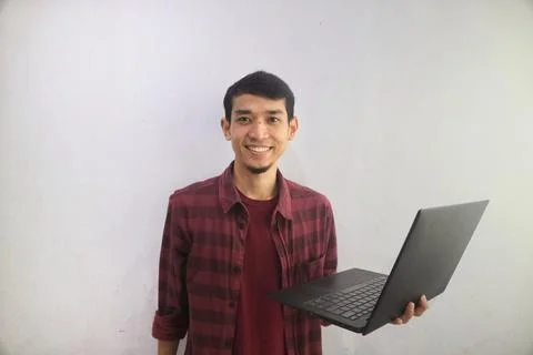 A man smiling happy while holding a laptop Stock Photos