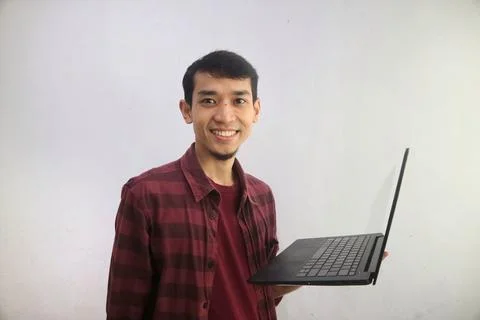 A man smiling happy while holding a laptop Foto stock