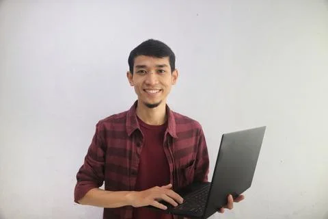 A man smiling happy while holding a laptop Stock Photos
