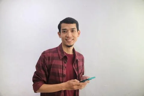 A man smiling happy while holding a handphone Stock Photos