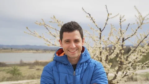 Man smiling. Looking at camera, nature on the background Видео 93014449