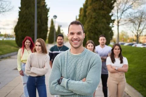 Man smiling looking at the camera while standing in front of a group of people. 스톡 사진