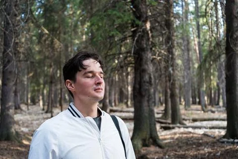 Man smiling in a sunlit forest Stock Photos