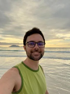 Man smiling at sunset in the ocean Stock Photos