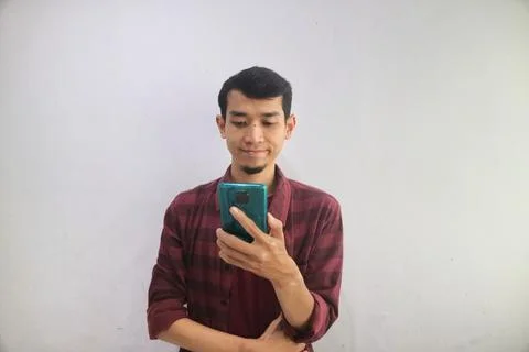 A man smiling when looking to his handphone Foto stock