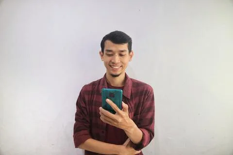 A man smiling when looking to his handphone Stock Photos