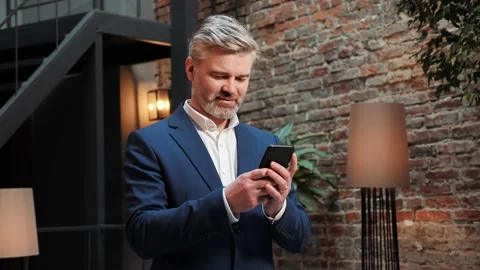 Man smiling while holding scrolling smartphone. Business Mobile app. Video stock 232472415