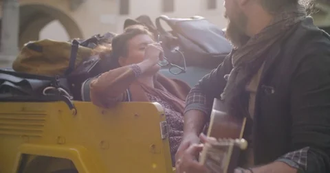 Man smiling while playing guitar music with girlfriend.Woman listening to 動画素材 82589352