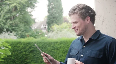 Man smiling while reading his mail on ipad Stock Footage