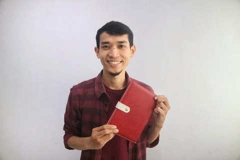 A man smiling while showing note book Stock Photos