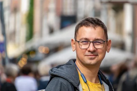 Man smiling while standing in crowded urban street Stock Photos