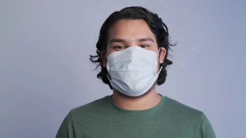 A man smiling while taking a mask off Stock Footage