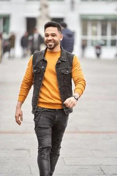 Man smiling while walking outdoors on the street. Foto stock