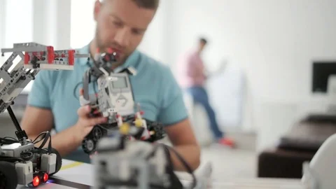 Man smiling while working on robotic machine Stock Footage 77979495