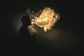 The man smoke an electric cigarette against the background of the flame Photo