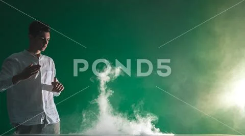 The man smoke an electric cigarette and gesture on the green background Stock Photos