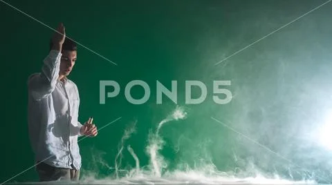 The man smoke an electric cigarette and gesture on the green background Stock Photos