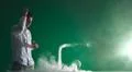 The man smoke an electric cigarette and gesture on the green background Photo