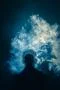 The man smoke an electric cigarette on the background of a bright light Photo