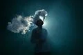 The man smoke an electrical cigarette on the dark background Photo