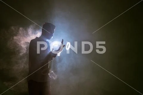 The man smoke an electrical cigarette with a ring on the dark background Stock Photos