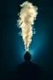 The man smoke an electronic cigarette against the background of bright light Photo