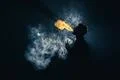 The man smoke an electronic cigarette against the background of bright light Photo