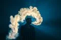 The man smoke an electronic cigarette on the background of the bright light Photo