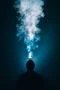 The man smoke an electronic cigarette on the background of bright light Photo