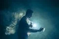 The man smoke an electronic cigarette with a ring on the bright light backg.. Photo