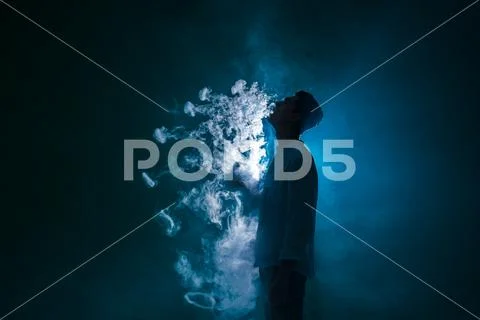 The man smoke an electronic cigarette with a ring against the background of.. Stock Photos